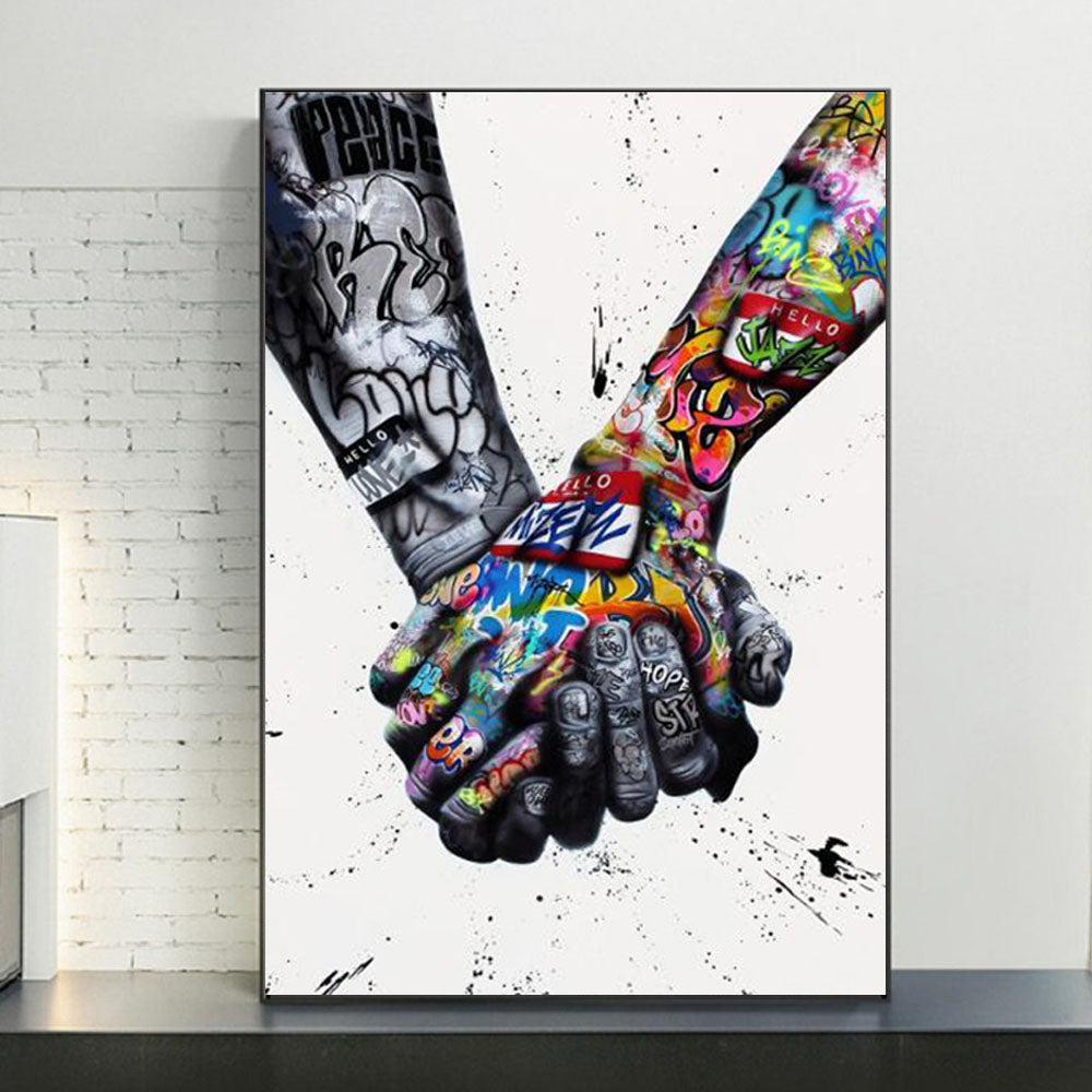 Quadro su tela “Mano nella Mano Graffiti” in stile street art, due mani che si intrecciano tra colori vivaci e scritte urbane, perfetto per un arredo emozionale