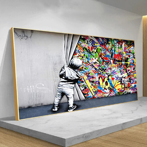 Quadro “Street Art di Banksy”: bambino che srotola una tenda rivelando graffiti colorati dietro il muro, stampa su tela.