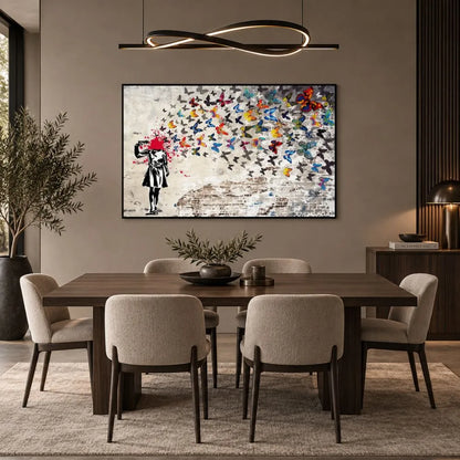 Quadro su tela con cornice nera di Banksy, riproduzione della bambina che si spara alla testa, trasformando il colpo in un’esplosione di farfalle colorate. Quadro urban e simbolico.