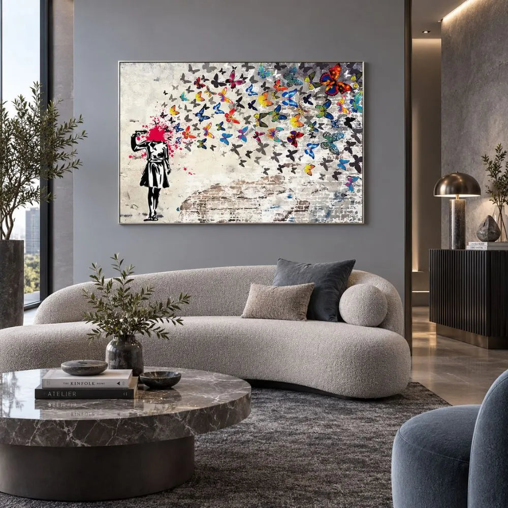 Quadro su tela con cornice argento di Banksy, riproduzione della bambina che si spara alla testa, trasformando il colpo in un’esplosione di farfalle colorate. Quadro urban e simbolico.