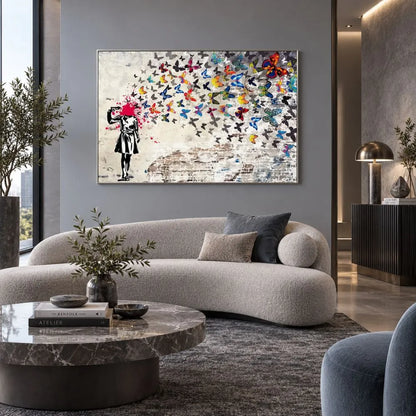 Quadro su tela con cornice argento di Banksy, riproduzione della bambina che si spara alla testa, trasformando il colpo in un’esplosione di farfalle colorate. Quadro urban e simbolico.