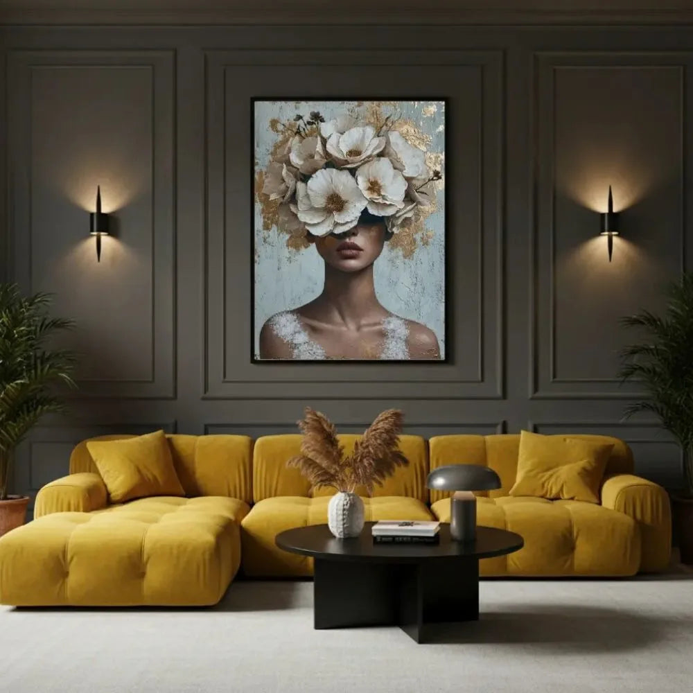 Anima in fiore quadro su tela con cornice nera di una donna con il volto nascosto da un rigoglioso copricapo di fiori bianchi e dettagli in foglia oro su uno sfondo materico azzurro e bianco.