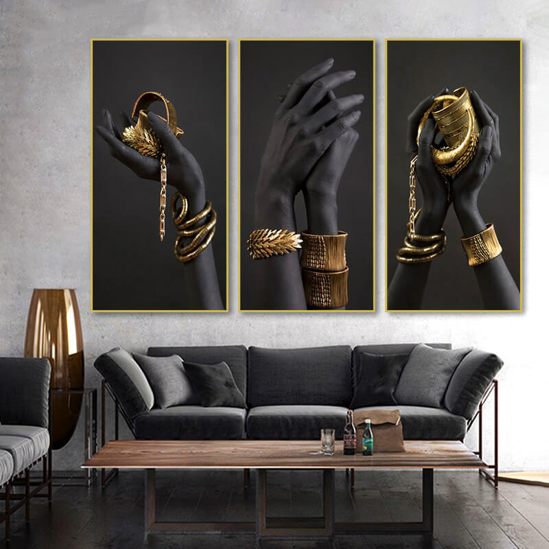 Quadro “Passione Gold” con mani nere che indossano bracciali e anelli dorati, rappresentazione di lusso e raffinatezza.