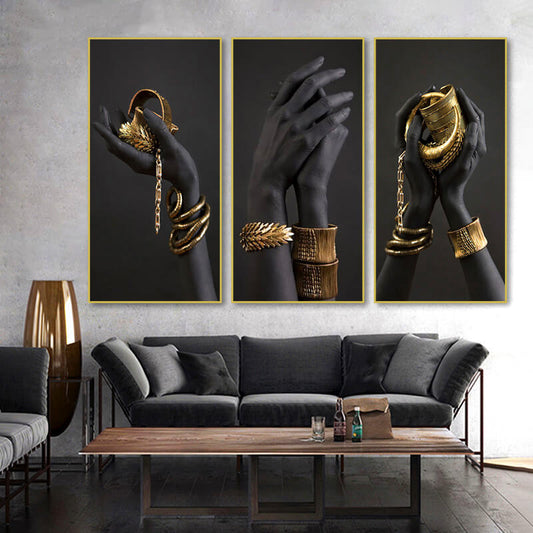 Quadro “Passione Gold” con mani nere che indossano bracciali e anelli dorati, rappresentazione di lusso e raffinatezza.