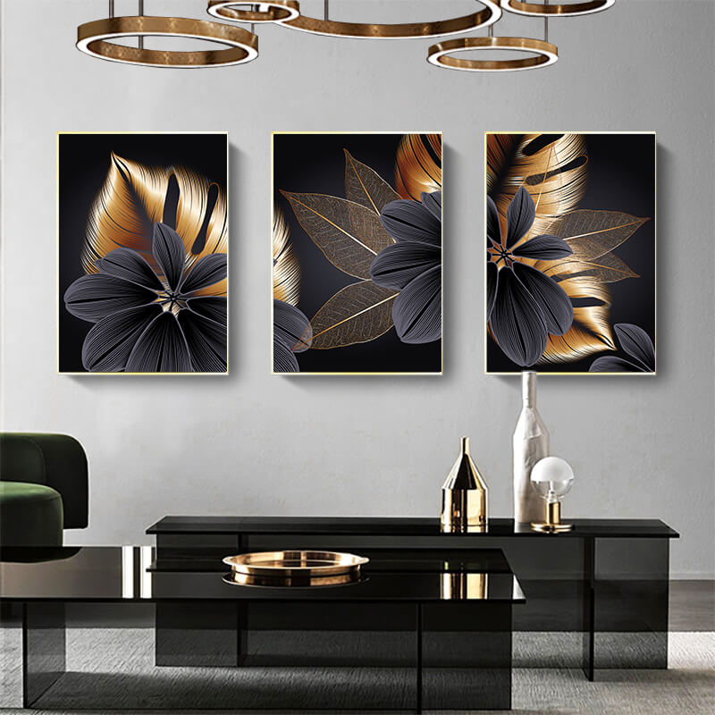 Set di tre quadri “Essenza Floreale”: fiori stilizzati su sfondo nero con petali grigi e sfumature oro.