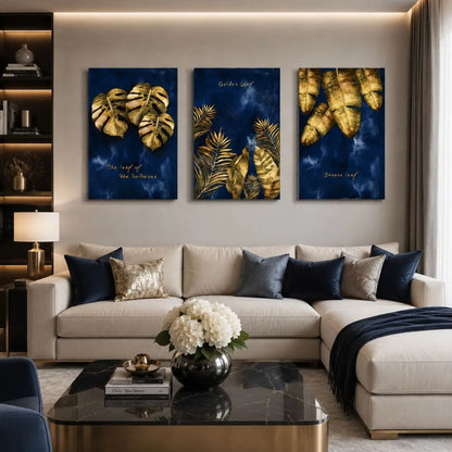 Set di tre quadri “Foglie Dorate”: foglie dorate su sfondo blu intenso, composizione elegante e armoniosa.