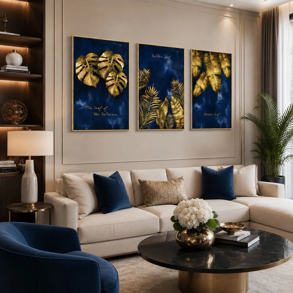 Set di tre quadri “Foglie Dorate”: foglie dorate su sfondo blu intenso, composizione elegante e armoniosa.