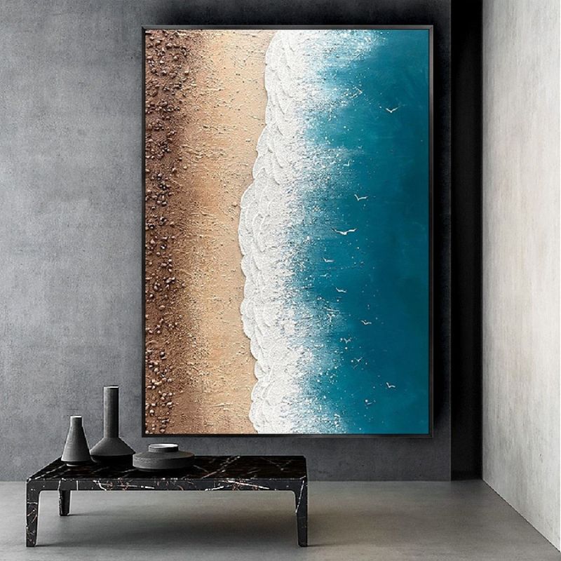 Quadro “Incontro infinito” appeso in soggiorno moderno: composizione verticale che mostra la transizione tra sabbia e onde.