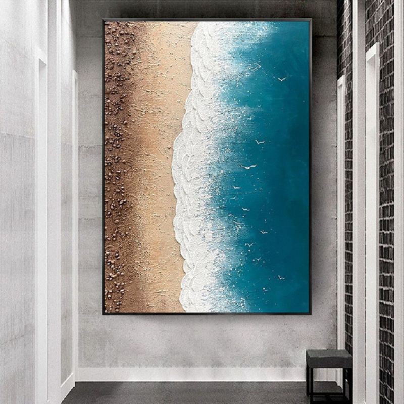Quadro “Incontro infinito” appeso in soggiorno moderno: composizione verticale che mostra la transizione tra sabbia e onde.