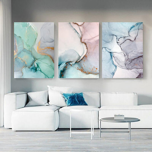 Set "Sfumature Chiare" appeso in soggiorno moderno: trittico di quadri su tela con sfumature delicate.